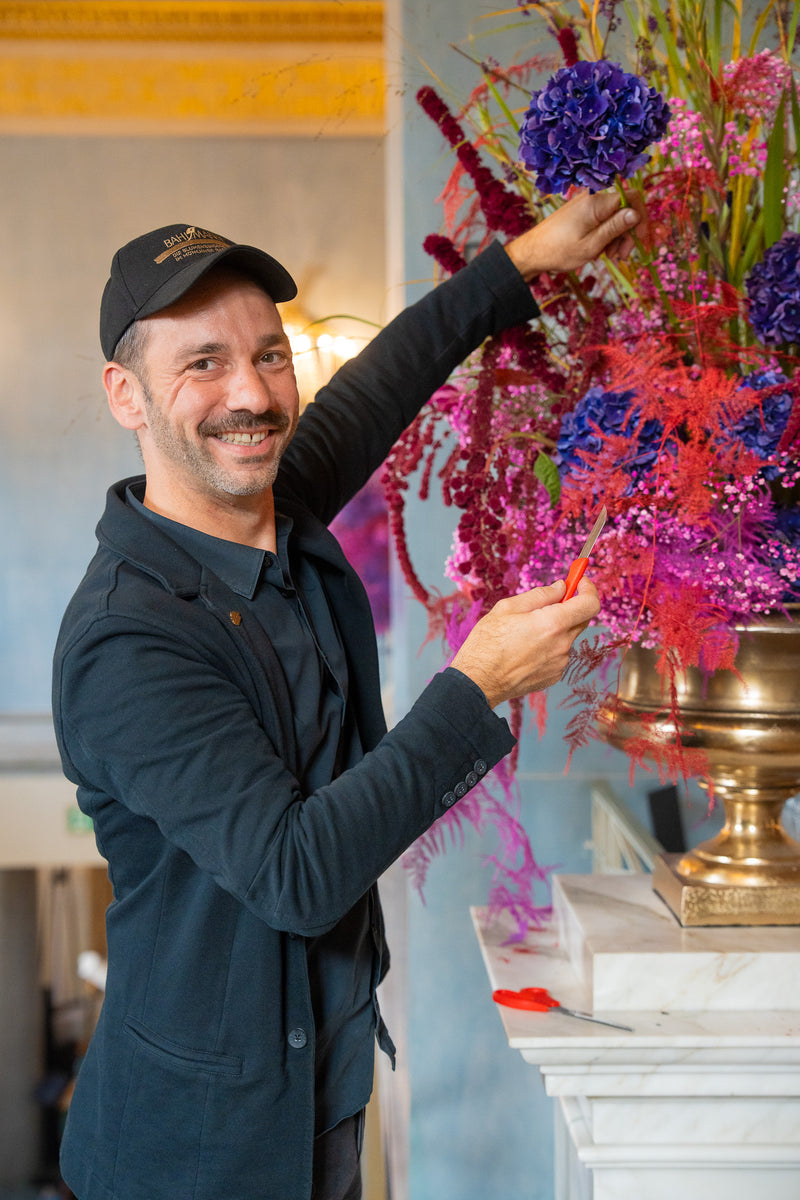 Bahlmann Geschäftsführer Steffen Laible, bei der Arbeit an einem Blumenarrangement in der Bayerischen Staatsoper zum Benefiz-Bühnendinner.