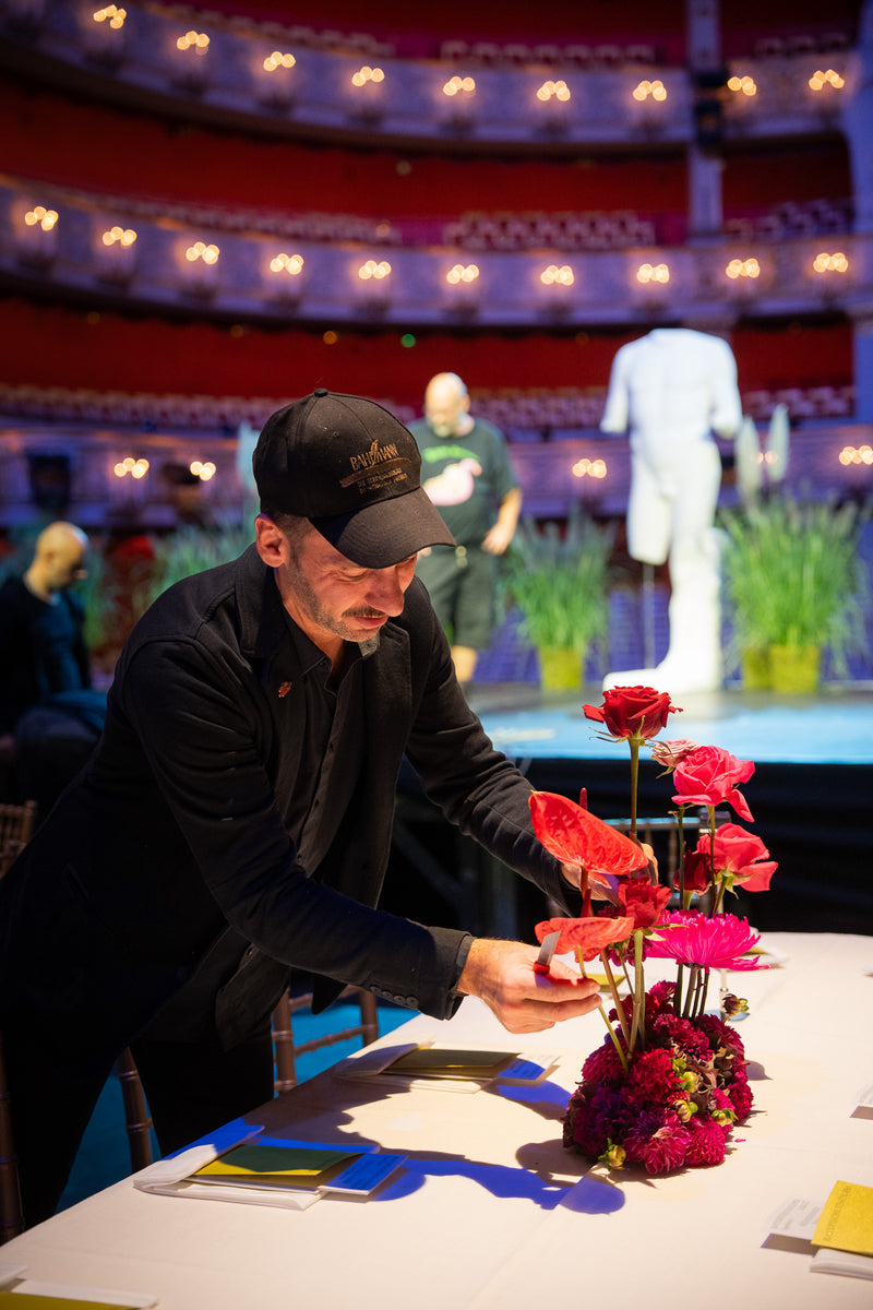Blumen Bahlmann Geschäftsführer Steffen Laible platziert ein Blumengesteck auf einem festlich dekorierten Tisch der Bayerischen Staatsoper.