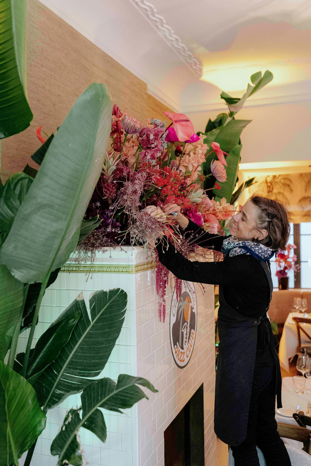 Blumen Bahlmann Eventfloristik Mitarbeiterin beim Aufstellen eines Blumenarrangements für ein Event in München.