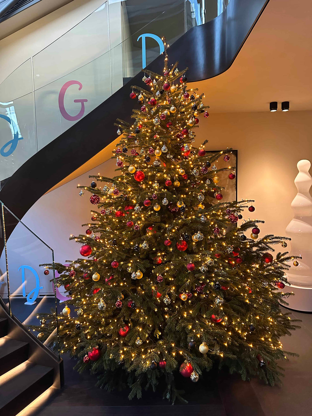 Ein großer Weihnachtsbaum mit, in Deutschland hergestellten, Glaskugeln von Blumen Bahlmann geschmückt, in den Geschäftsräumen eines Münchner Unternehmens.