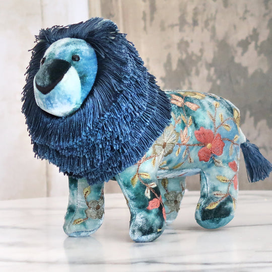 Besticktes Löwen-Kuscheltier aus samtigem Stoff mit floralen Seidenstickereien in Indigoblau. Blumen Bahlmann München