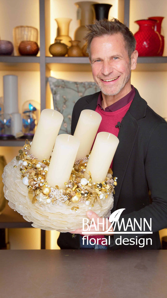 Der Adventskrant Perlmutt aus der neuen Kollektion 2025, präsentiert von Bahlmann Geschäftsführer Michael. Ein Adventskranz in schickem Weiß und einem marinen Thema mit goldenen Ornamenten.
