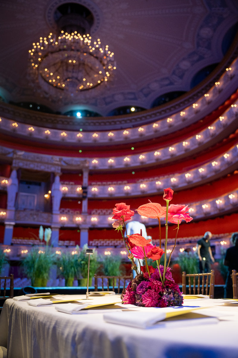 Majestätisches Bild der Bayerischen Staatsoper mit Bahlmann Tischdekoration im Vordergrund. Ein Blumengesteck in satten Rottönen.