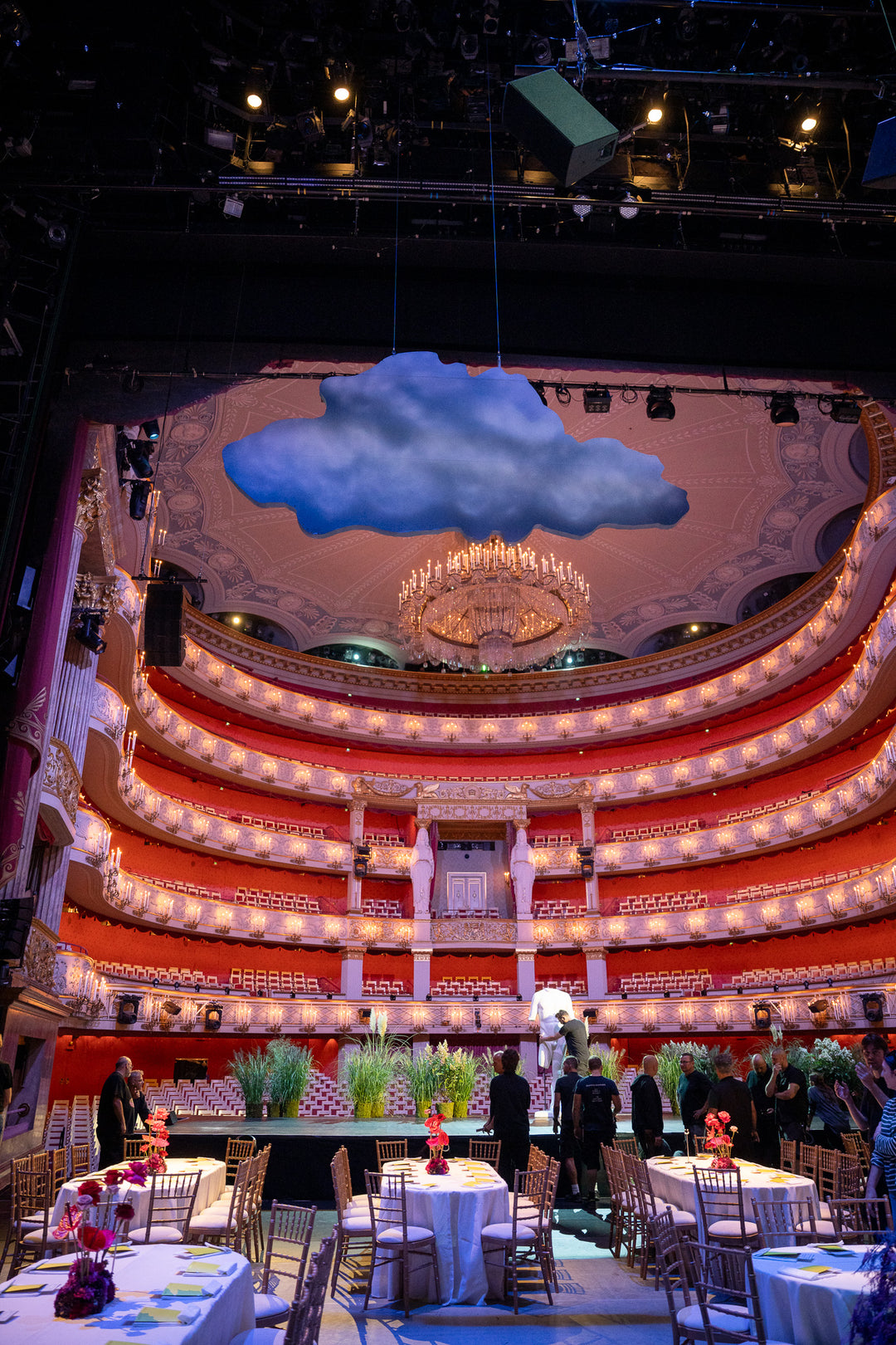 Ein Blick von der Bühne der Bayerischen Staatsoper in München auf die Zuschauerränge. Im Vordergrund sind festliche Tische dekoriert mit Blumengestecke von Bahlmann.