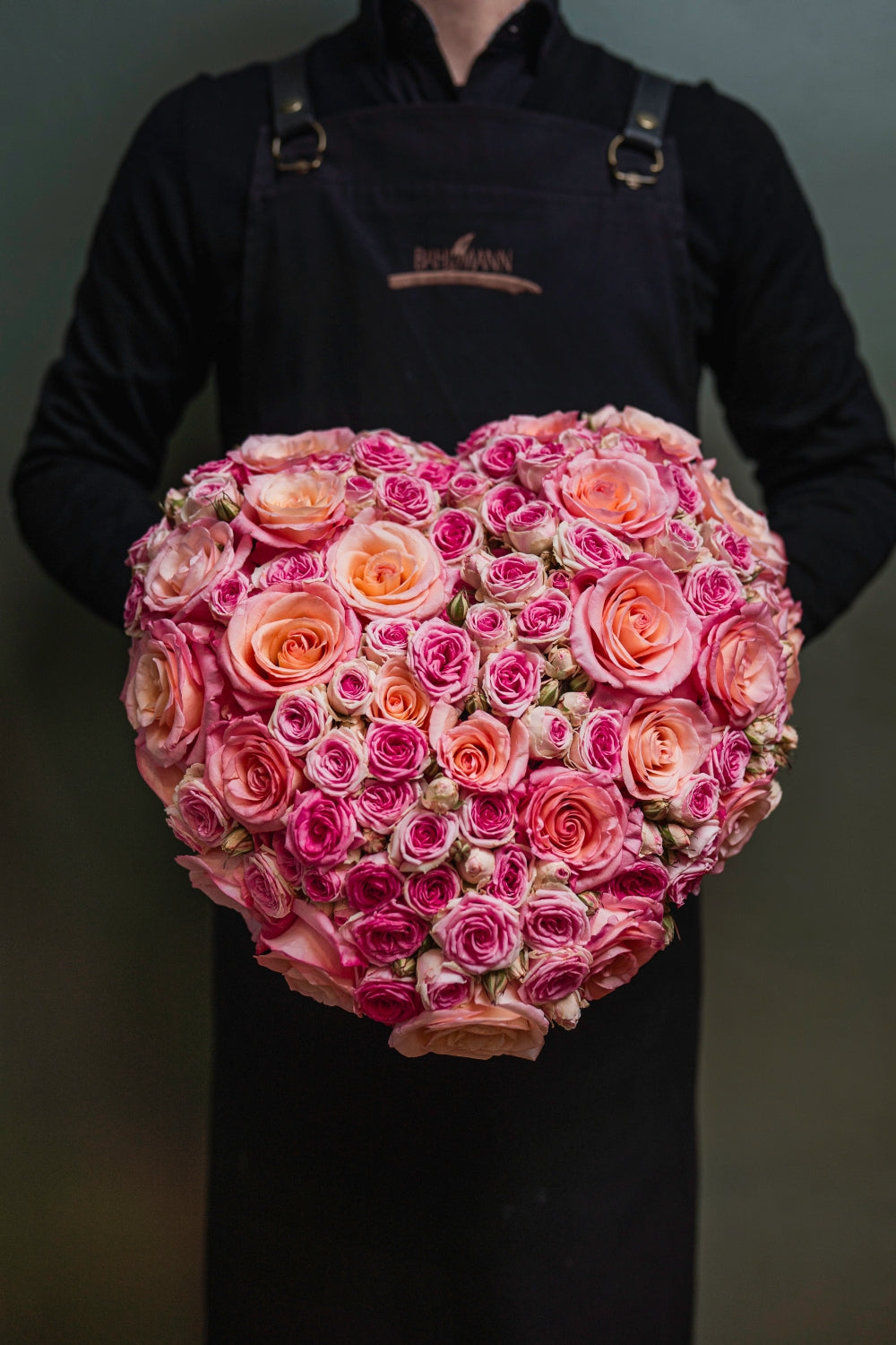 Ein großes Blumengesteck aus Rosen in Händen gehalten, von Blumen Bahlmann in München
