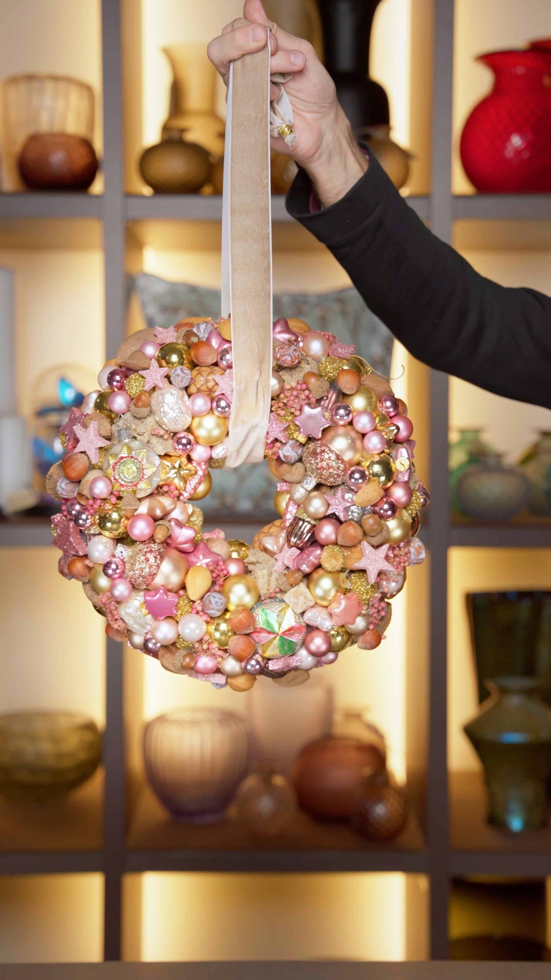 Ein weihnachtlicher Türkranz in Rosa und Gold gehalten, mit Kugeln und Sternchen. 