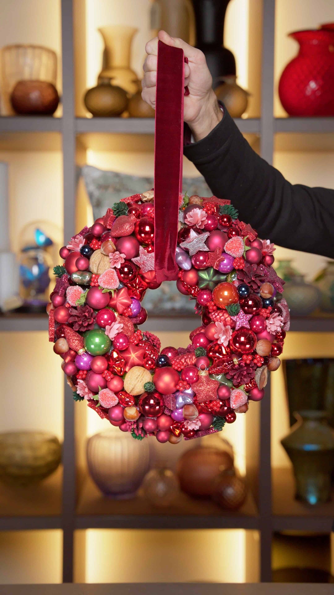 Ein weihnachtlicher Türkranz in tiefem Weihnachtsrot und vielen Kugeln.