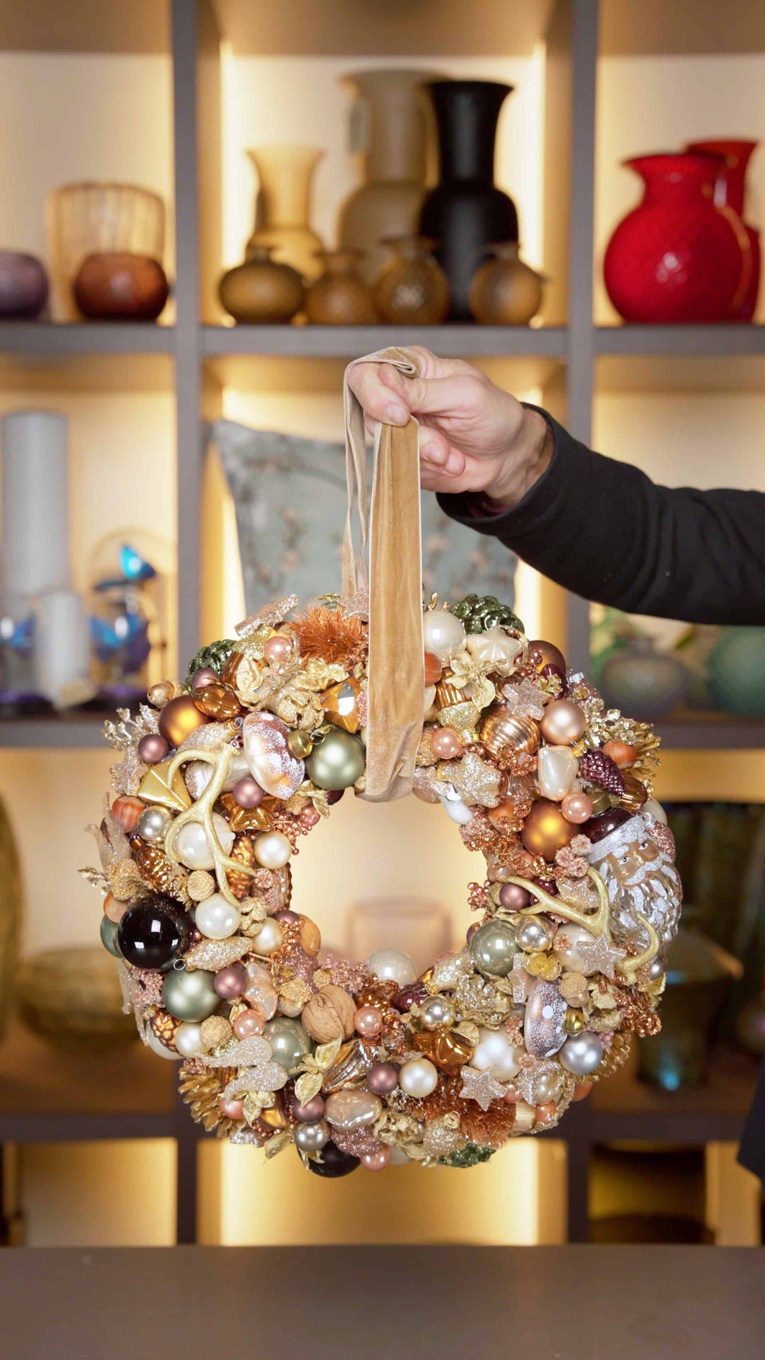 Ein Türkranz in Weiß und Gold gehalten mit einer großen Kugel in Nikolausform und Rauschebart.