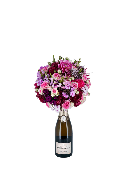 Eine Flasche Champagner von Louis Roederer, die am Korken mit einem wunderschönen Blumengesteck von Blumen Bahlmann verziert wurde und als Geschenk bestellt werden kann.