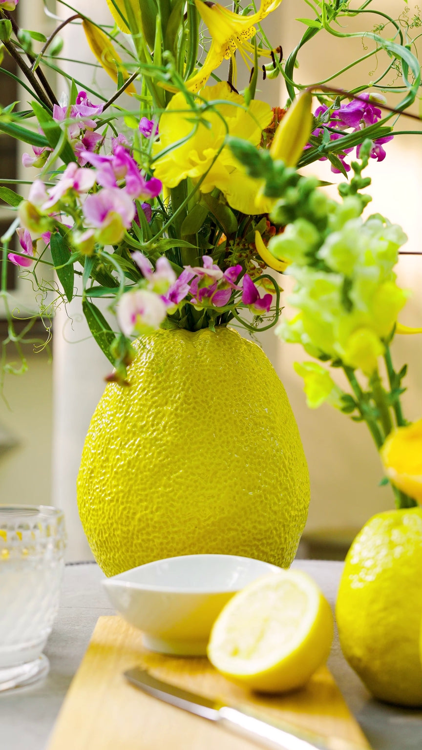 Blumen Bahlmann Keramikvase in Limettenform auf Terrassentisch, arrangiert mit Zitronenlimonade im Sommer.
