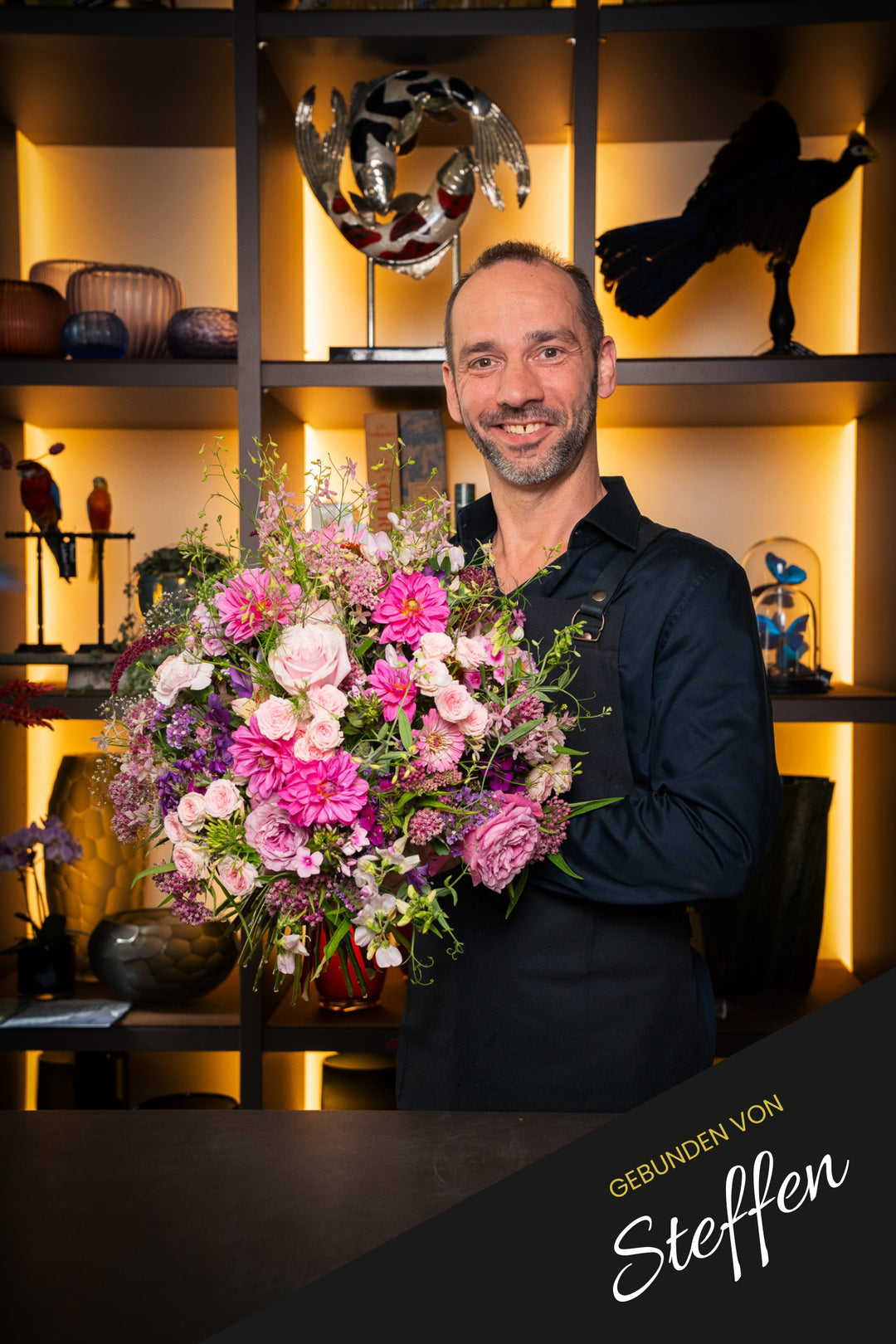 Bahlmann Geschäftsführer Steffen hält den Blumenstrauß Pink Cloud, im Bahlmann Showroom floral.design in München, in die Kamera.