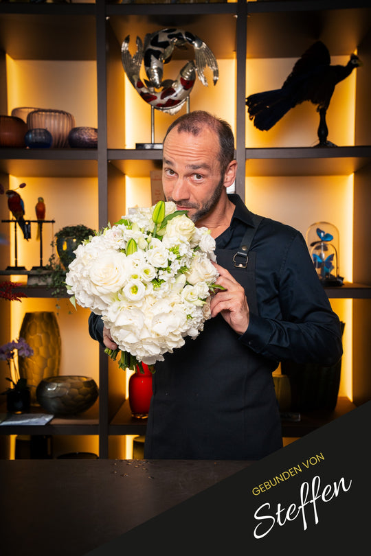 Weißer Blumenstrauß "Weiße Pracht" – handgebunden und präsentiert von Geschäftsführer Steffen im Bahlmann Showroom in München.