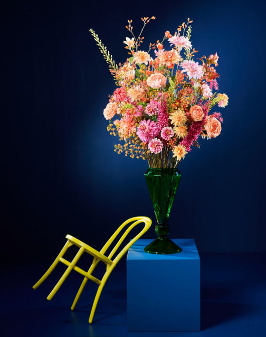 Farbenfrohes Seidenblumenarrangement mit Blüten in Pink, Apricot und Rosé in grüner Glasvase von Blumen Bahlmann München