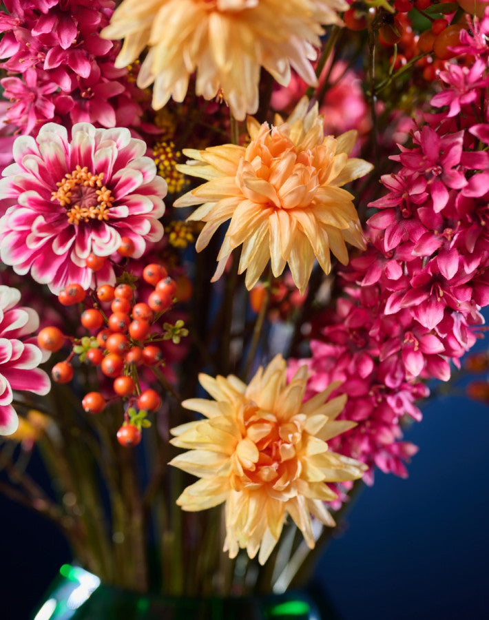 Modernes Seidenblumen-Gesteck mit kräftigen Blütenfarben und dekorativer grüner Vase von Blumen Bahlmann München