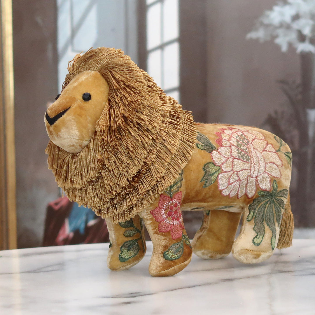 Besticktes Löwen-Kuscheltier aus samtigem Stoff mit floralen Seidenstickereien in Dunkelgelb. Blumen Bahlmann München