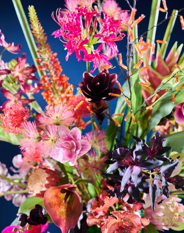 Modernes Seidenblumen-Gesteck mit lebendigen Farben und dekorativer grüner Vase von Blumen Bahlmann München