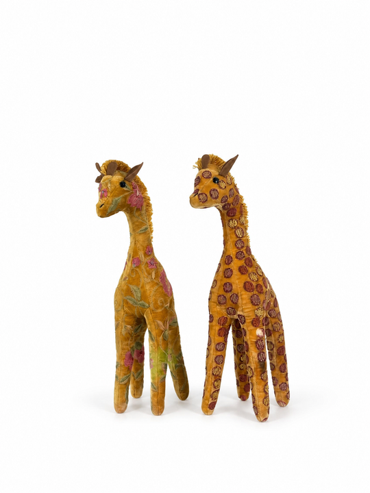 Zwei Anke Drechsel Deko-Giraffen aus goldfarbenem Samt, eine mit floraler Stickerei, eine mit Tupfenmuster, nebeneinander stehend – Blumen Bahlmann München