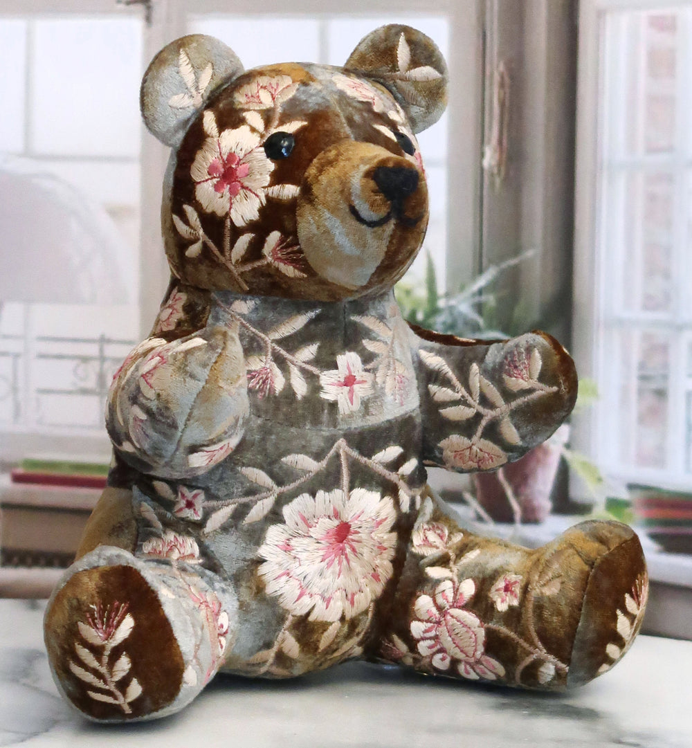 Handgestickter Teddybär in Schokobraun von Anke Drechsel aus weichem Stoff mit liebevollen Details, sitzend mit freundlichem Gesichtsausdruck. Blumen Bahlmann München