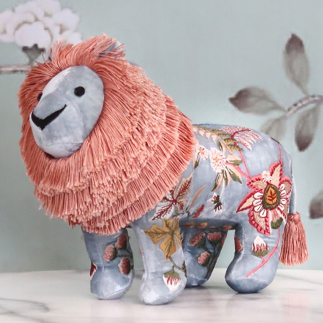 Besticktes Löwen-Kuscheltier aus samtigem Stoff mit floralen Seidenstickereien in Blaugrau/rosa. Blumen Bahlmann München