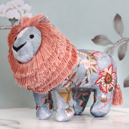 Besticktes Löwen-Kuscheltier aus samtigem Stoff mit floralen Seidenstickereien in Blaugrau/rosa. Blumen Bahlmann München