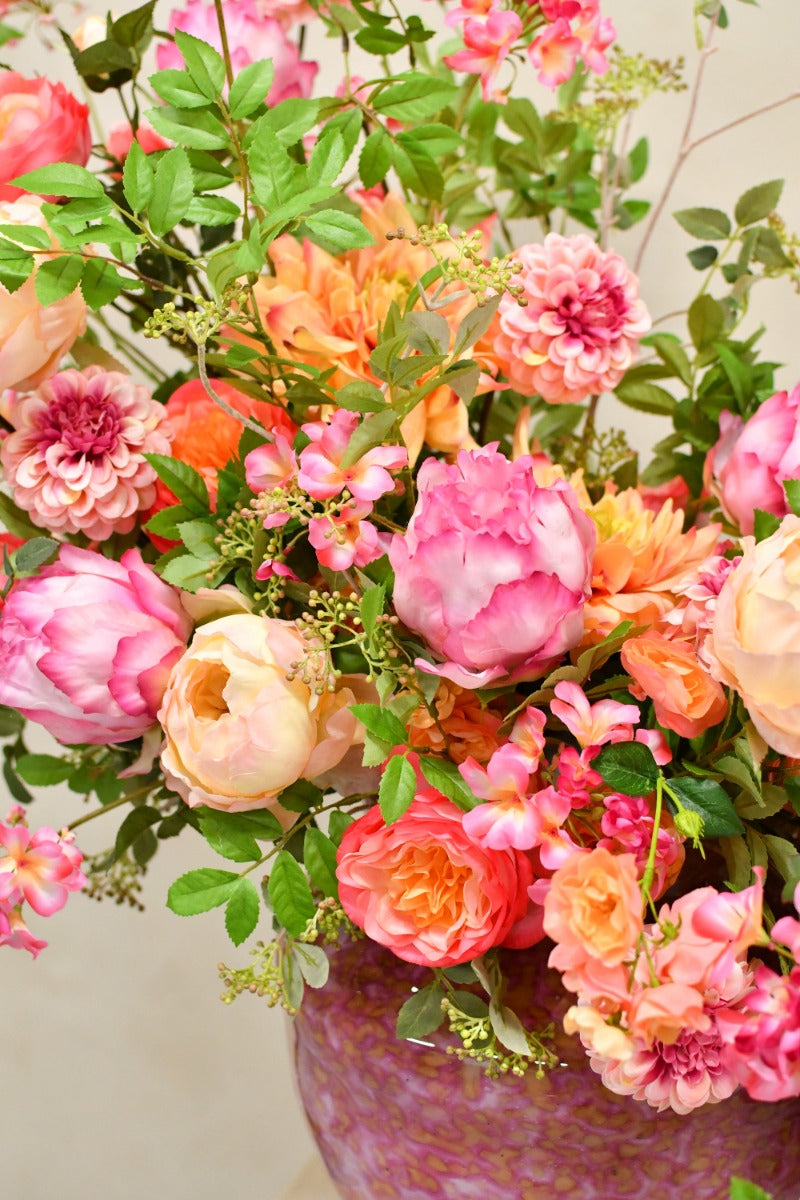 Großes künstliches Blumenarrangement mit Rosen, Pfingstrosen und zarten Blütenzweigen in einer runden Vase mit Farbverlauf. Blumen Bahlmann München