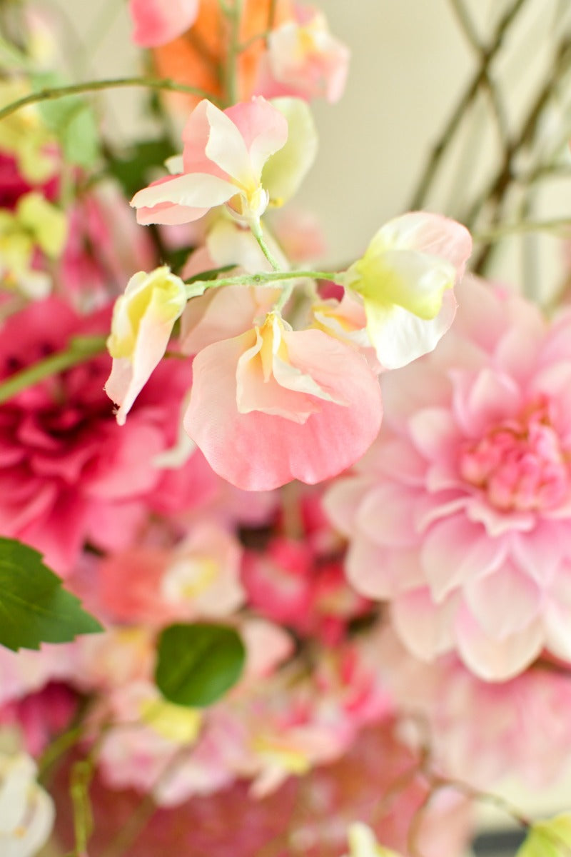 Elegantes Kunstblumenarrangement in sommerlichen Pastell- und Pinktönen mit ausladender Form und schimmernder Vase. Blumen Bahlmann München