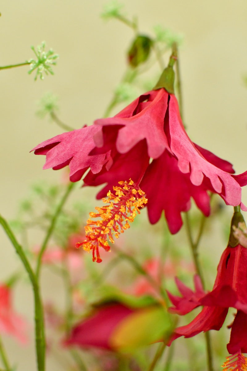 Farbenfrohes Seidenblumengesteck im Stil einer Sommerwiese mit kräftigen Blüten und dunklen Blattakzenten. Blumen Bahlmann München