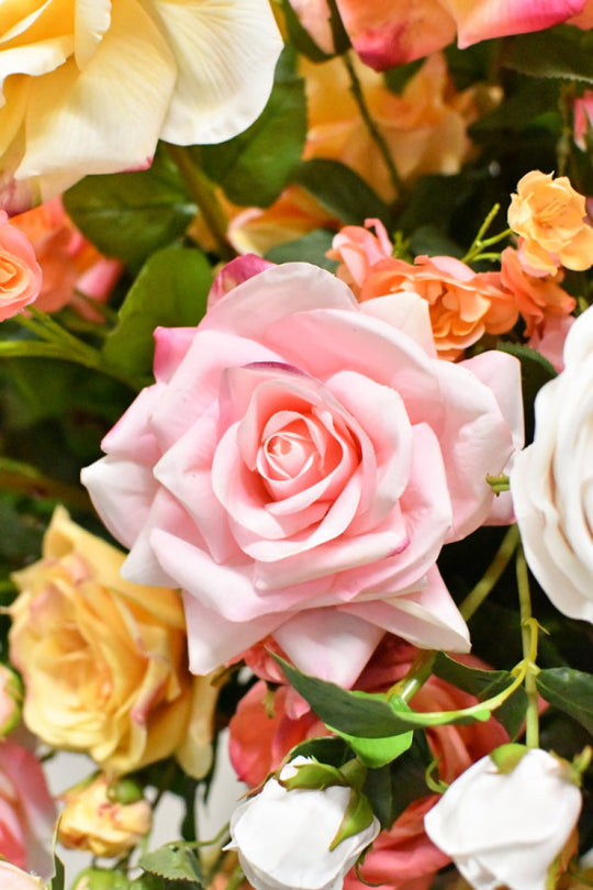 Hochwertiges künstliches Rosengesteck mit zarten Blütenzweigen und grünen Akzenten von Blumen Bahlmann München.