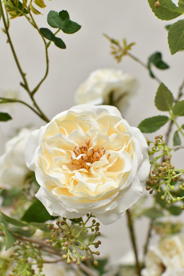Natürlich wirkendes Seidenblumen-Gesteck mit Rosen, Knospen und filigranem Grün von Blumen Bahlmann München.