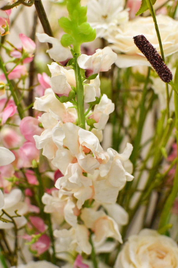 Hochwertiges künstliches Blumengesteck mit filigranen Zweigen, weißen Blüten und violetten Akzenten von Blumen Bahlmann München