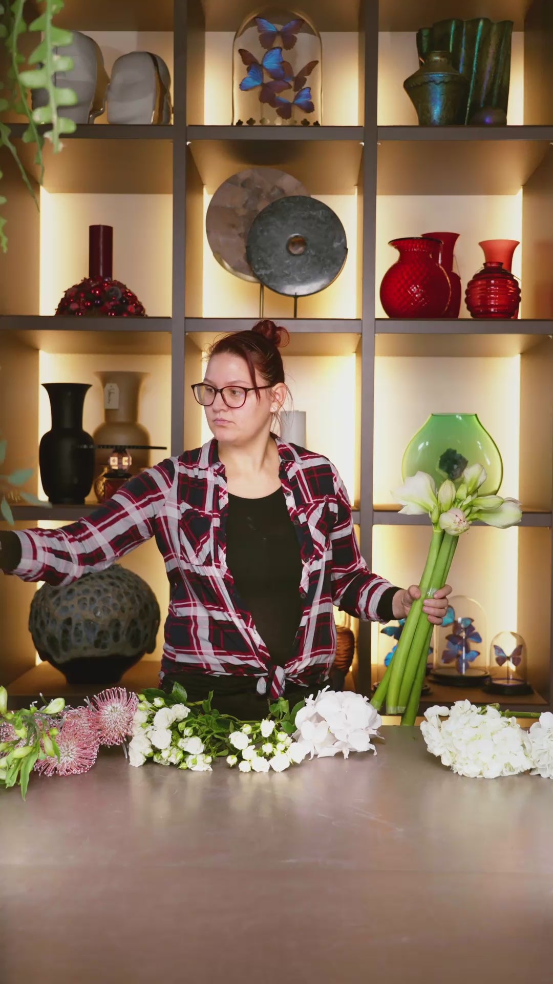 Blumen Bahlmann Mitarbeiterin bindet in Zeitraffer im SHOWROOM in München einen Winterstrauß aus weißen Hortensien, weißen Rosen, Nadelkissen, Amaryllis und Eukalyptus.
