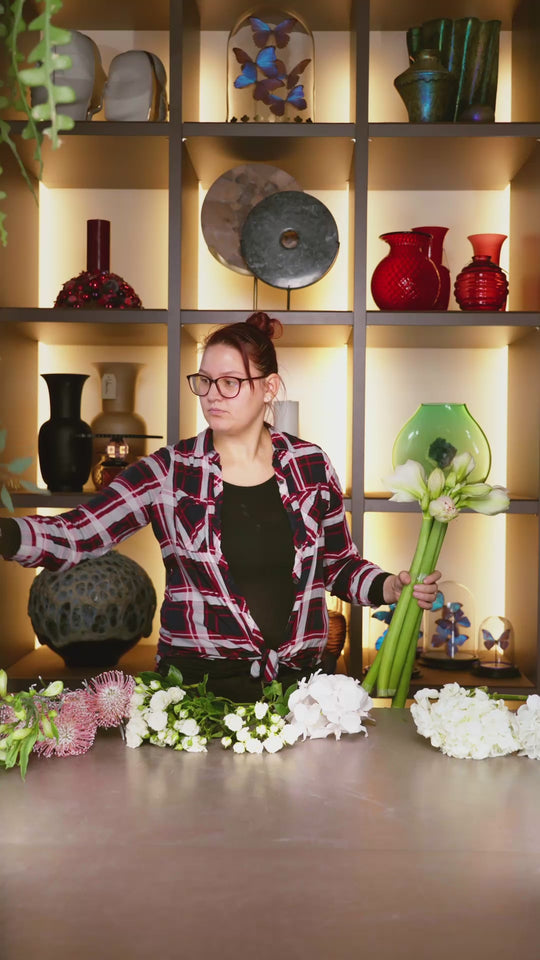 Blumen Bahlmann Mitarbeiterin bindet in Zeitraffer im SHOWROOM in München einen Winterstrauß aus weißen Hortensien, weißen Rosen, Nadelkissen, Amaryllis und Eukalyptus.
