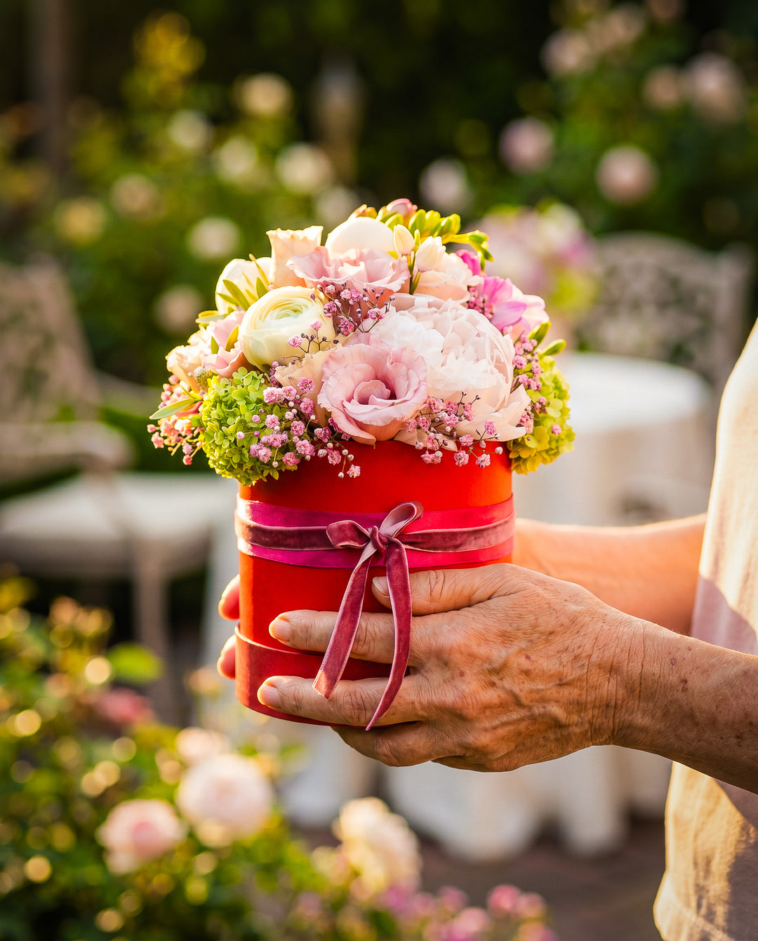Blumengesteck Love Box in Rot von Blumen Bahlmann in München. Eine rote Geschenkbox, die nach oben hin offen ist und mit unterschiedlichen Blumen wie Rosen, Pfingstrosen und Hortensien gesteckt ist. Das ganze Jahr erhältlich aber besonders beliebt zu Valentinstag und Muttertag.