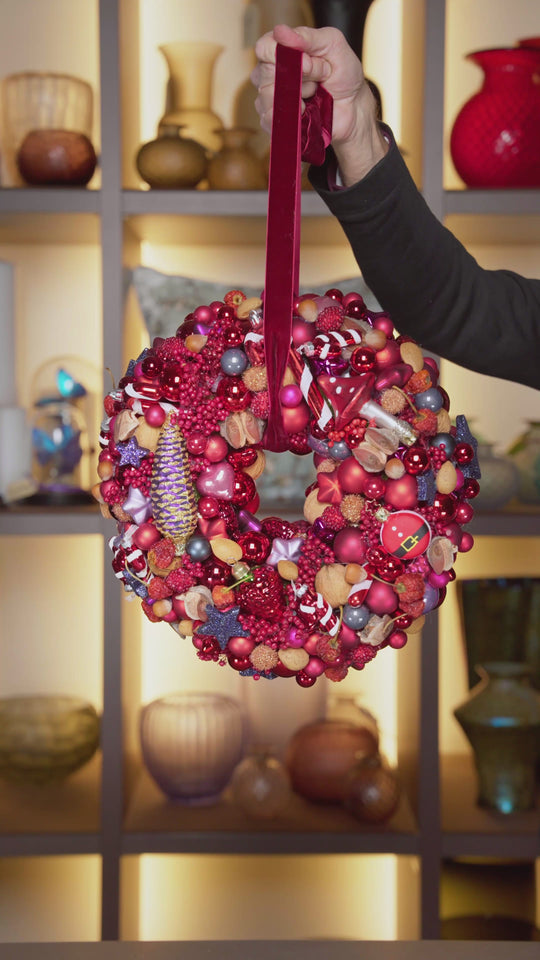 Ein Videoabfolge von insgesamt 4 weihnachtlichen Türkränzen von Bahlmann im gleichen Stil wie die Adventskränze. Der erste Türkranz ist in weihnachtlichem Rot mit Ornamenten wie Zuckerstangen und Kugeln. Der zweite ist in Rosa und Gold gehalten, mit Kugeln und Sternchen. Der dritte Türkranz ist wieder in tiefem Weihnachtsrot und vielen Kugeln. Der letzte Türkranz ist in Weiß und Gold gehalten mit einer großen Kugel in Nikolausform und Rauschebart.